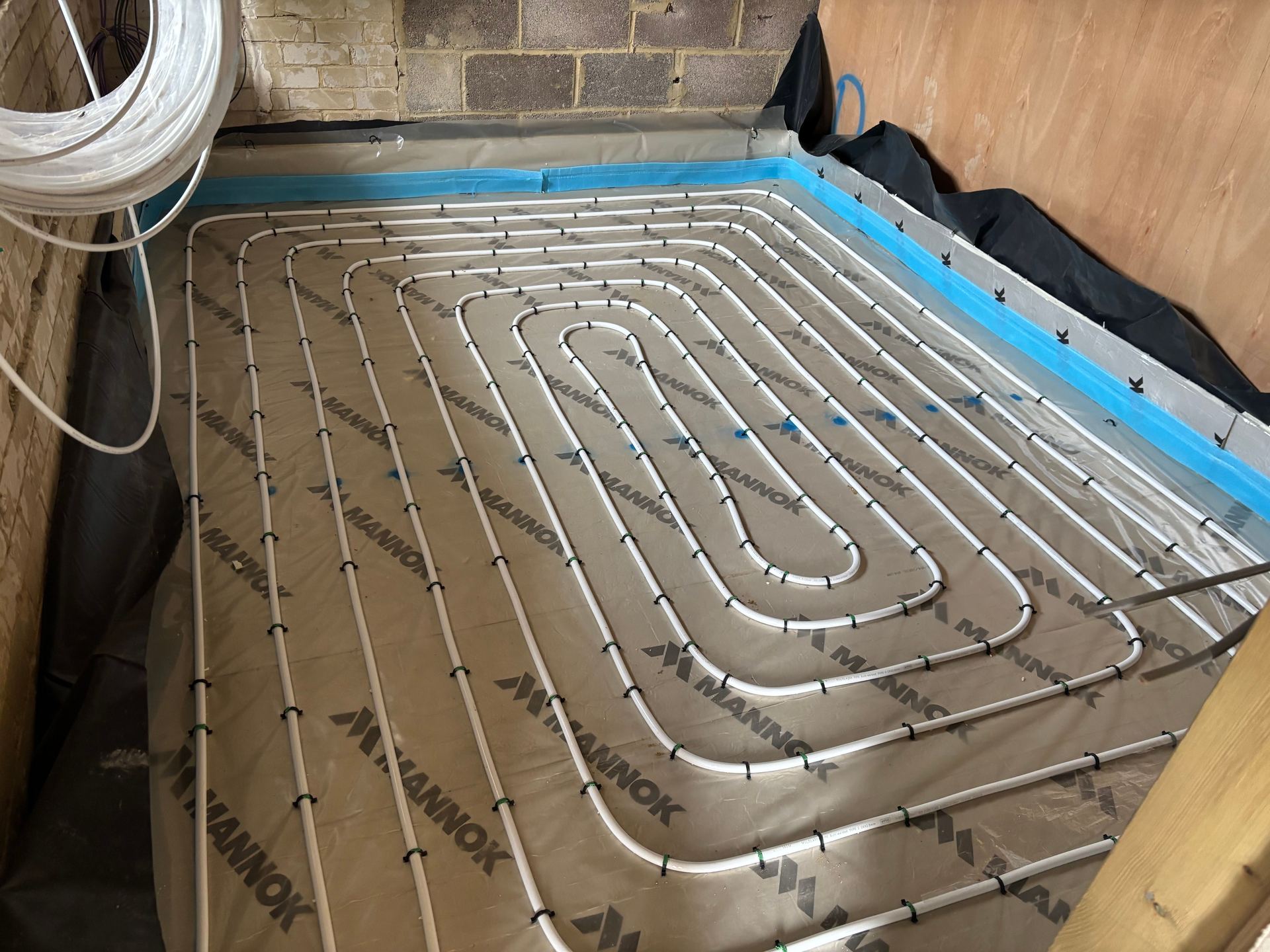In-screed underfloor heating pipe run in a spiral pattern over insulation